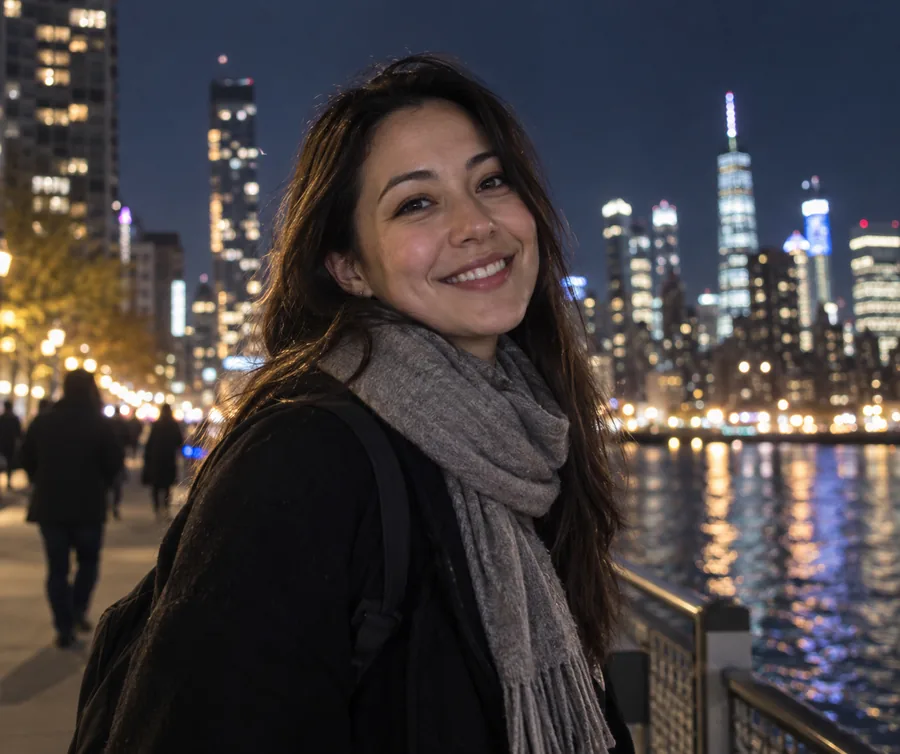 A smiling team member photographed in a city at night